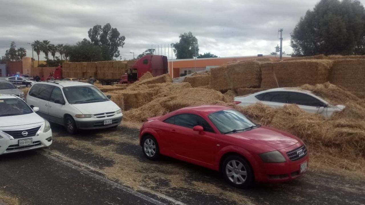 Tractocamión vuelca sobre carretera y daña a cuatro vehículos con la carga