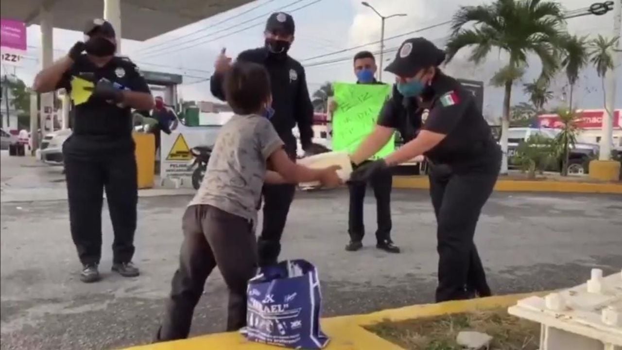 Policías le regalan un pastel a un pequeño que vende cubrebocas en el Día del Niño