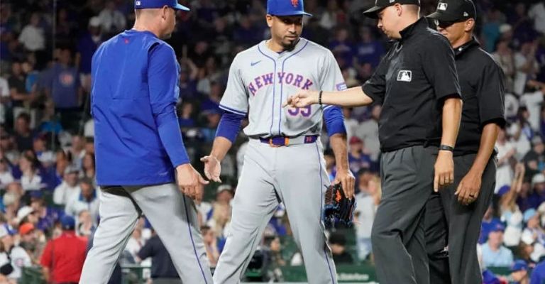 Díaz es revisado por el ampayer Vic Carapazza