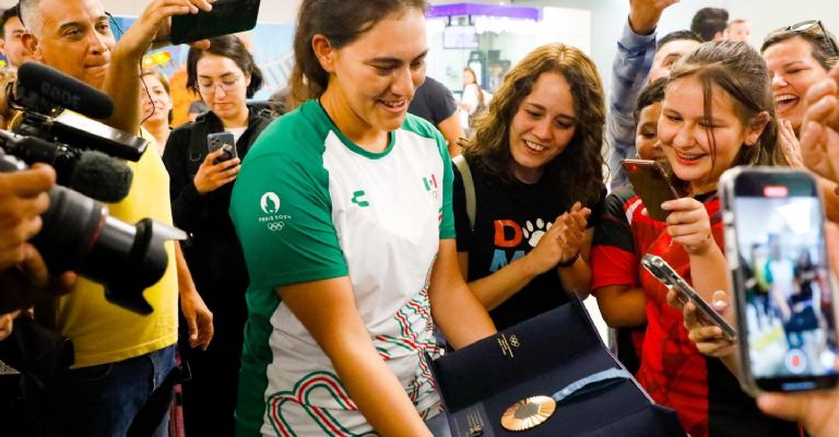 Alejandra Valencia presumiendo su medalla olímpica en su llegada