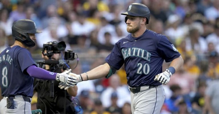 Raley es felicitado por el coach de tercera, tras su jonrón