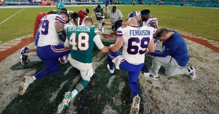 Jugadores de ambos equipos oran mientras Tua es atendido