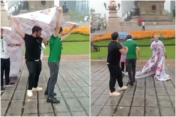 No respetaron; aficionados usan lona de desaparecidos para taparse de la lluvia en Ángel de Independencia.