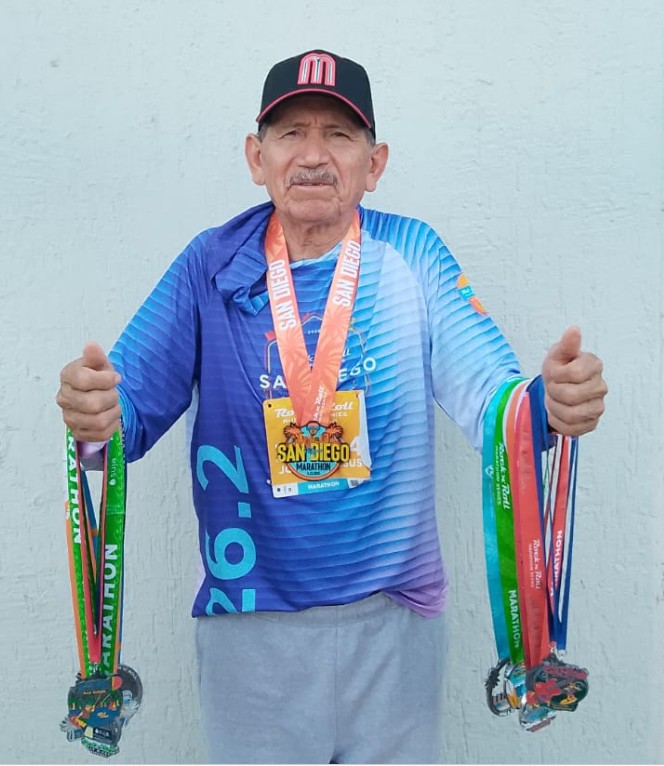 El también maestro muestra las medallas que ha recibido por su participación en esta carrera