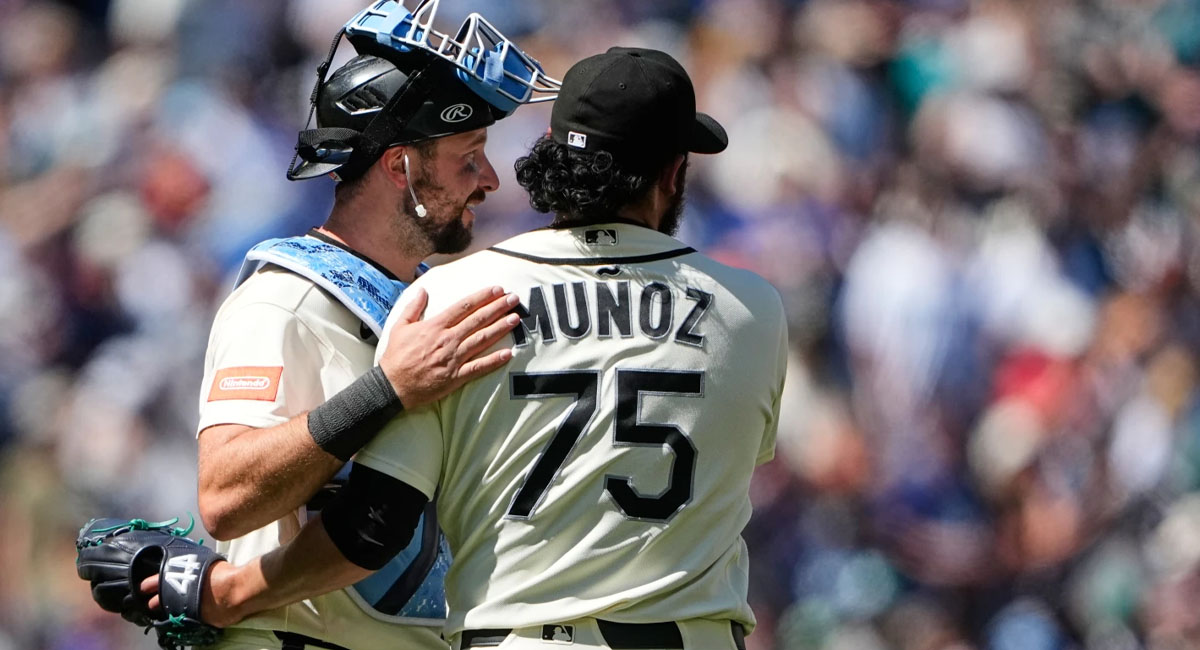 Muñoz es felicitado por su receptor, Cal Raleigh después de caer el out 27