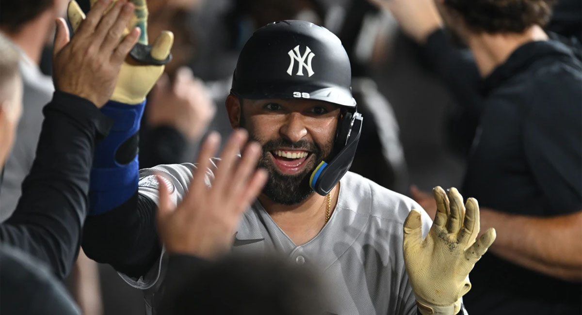 El venezolano es felicitado por sus compañeros en el dugout, después de conectar su vuelacercas