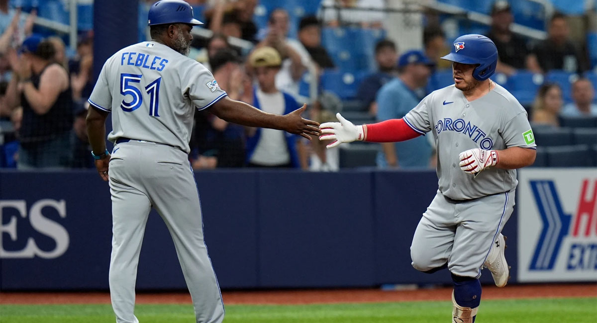 Kirk es felicitado por el coach de tercera, Carlos Febles durante su recorrido de bases