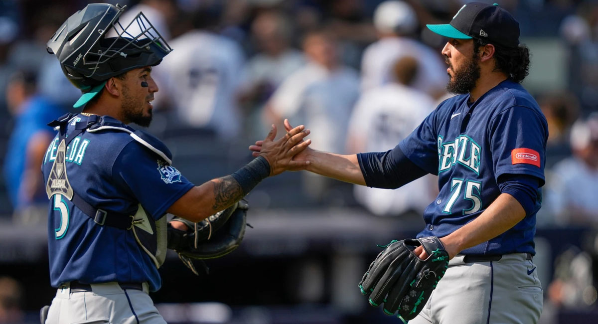 El cerrador mexicano es felicitado por Cal Raleigh, después de retirar el último out