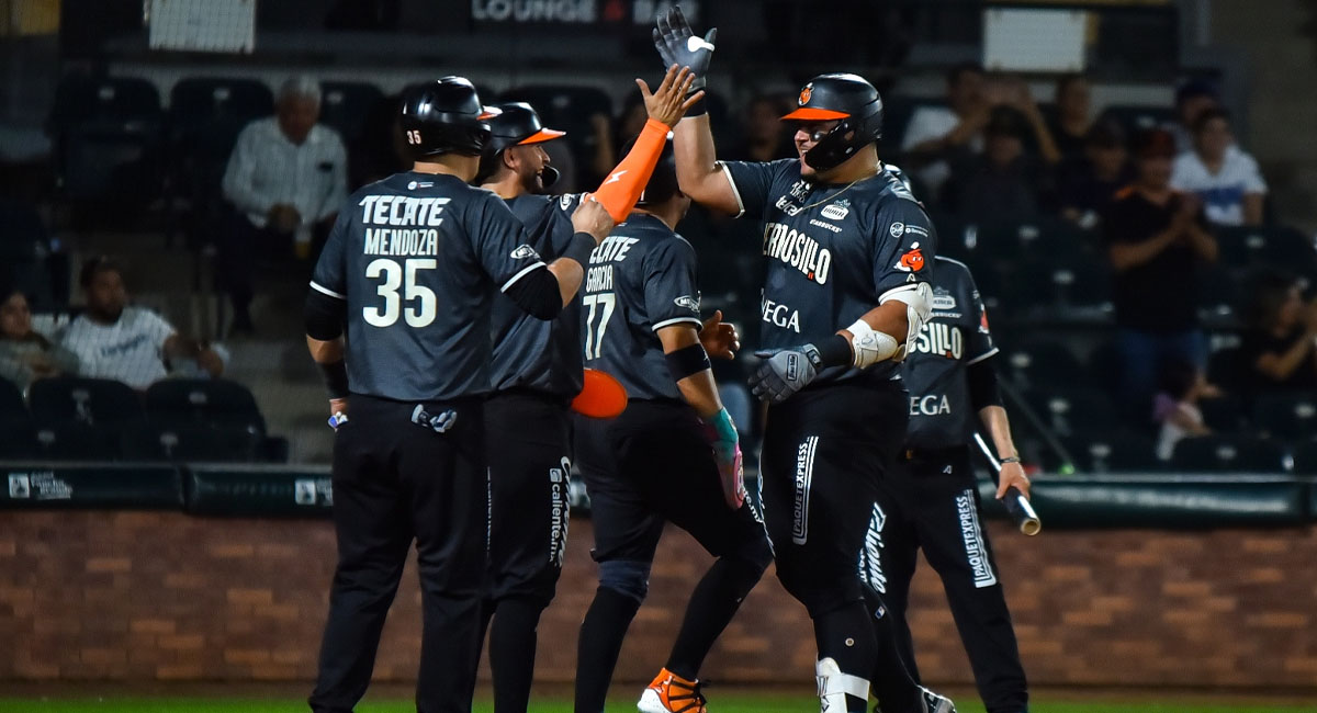 Ibarra es felicitado a su llegada al plato, después de conectar su grand slam en la séptima entrada
